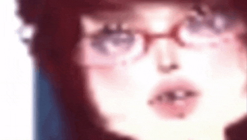 a woman wearing glasses and a hat is looking at the camera .