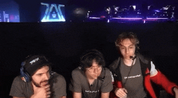 a group of people are sitting in front of a sign that says 7ax
