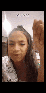 a woman is making a funny face while holding her hand up in the air .