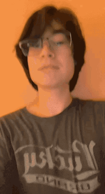 a young man wearing glasses and a black shirt that says ' u.s. navy ' on it