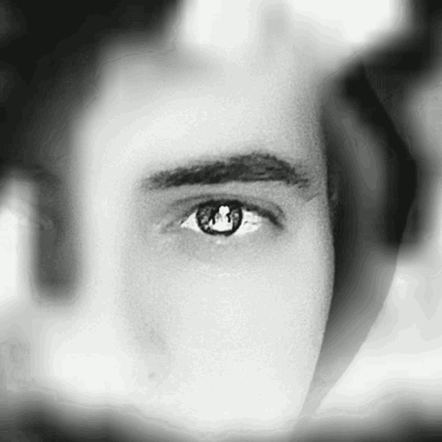 a black and white photo of a man 's eye with a keyhole in it