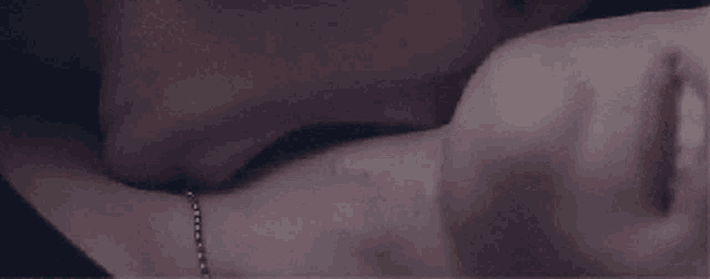 a man is kissing a woman on the neck while wearing a bracelet .