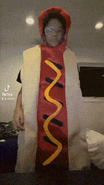 a person dressed in a hot dog costume with a swirl of mustard on it