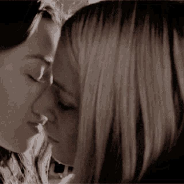 a close up of two women 's faces looking at each other
