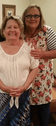 two older women are posing for a picture together .
