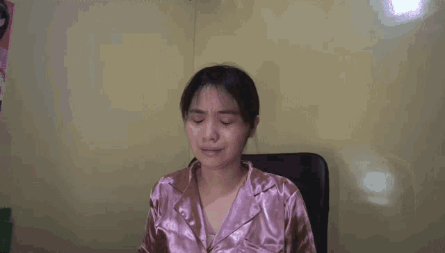 a woman is sitting in a chair with her eyes closed .