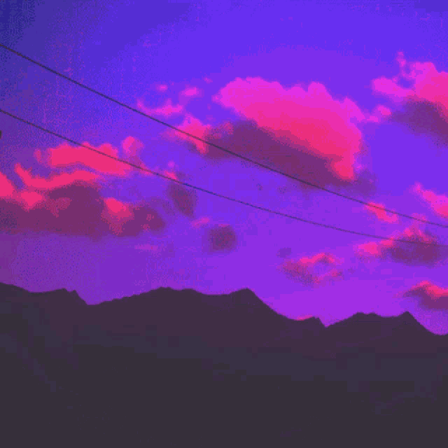 a purple sky with pink clouds and power lines