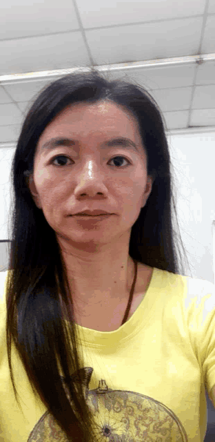 a woman in a yellow shirt with an apple on it