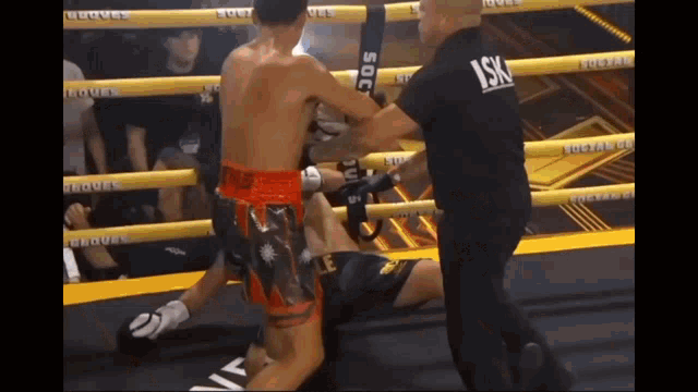 a referee in a boxing ring with the letters lsk on his sleeve