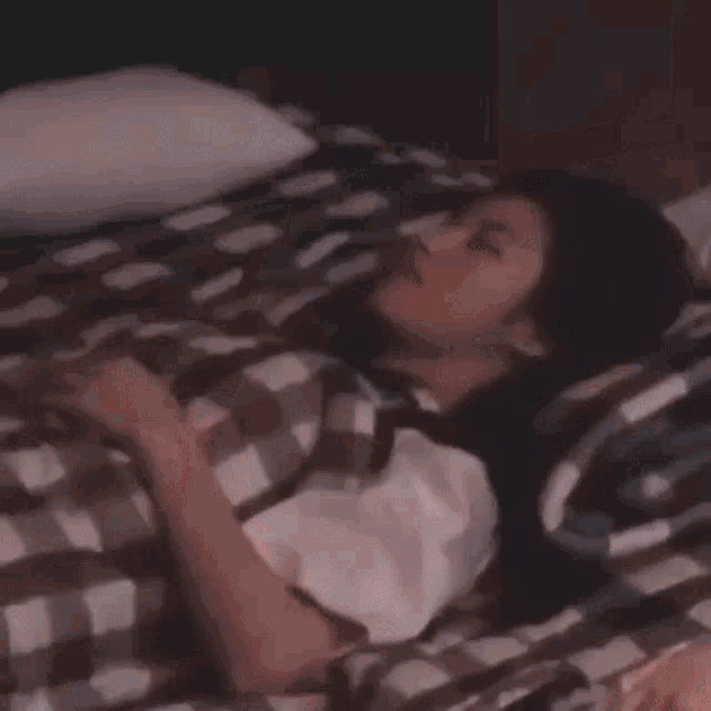 a group of people are laying on a bed in a room with an arrow pointing to the left .