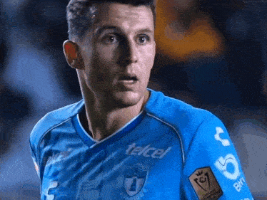 a man wearing a blue shirt that says telcel on the front