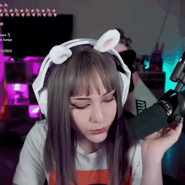 a girl wearing a headset with bunny ears looks at the camera