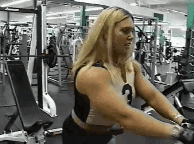 a woman is using a machine in a gym with the number 3 on her shirt