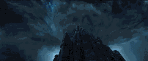 a mountain with a blue sky and clouds in the background