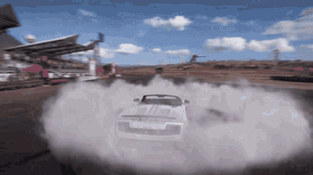 a white sports car is drifting on a track
