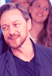 a man with a beard is smiling in front of a woman .