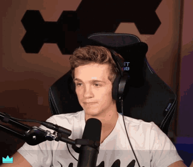 a man wearing headphones and a t-shirt that says ninja is sitting in a chair