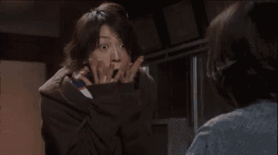 a woman is making a funny face while looking at another woman in a mirror .