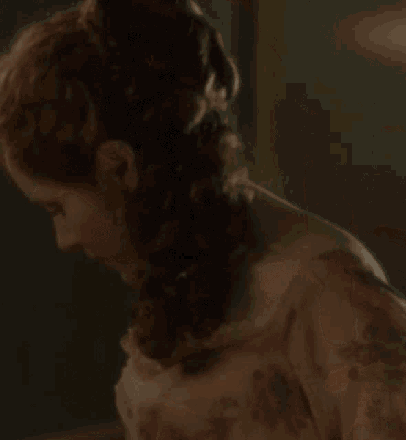 a close up of a woman 's face with a braid in her hair