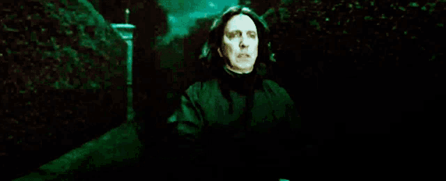 a woman in a black cloak is walking through a dark forest