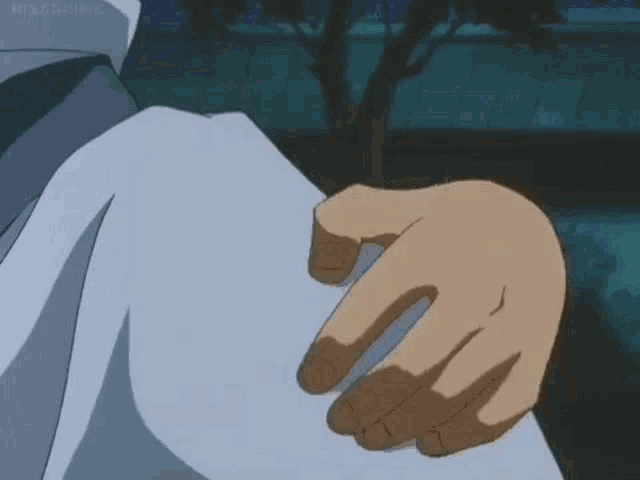 a close up of a person 's hand touching another person 's shoulder .