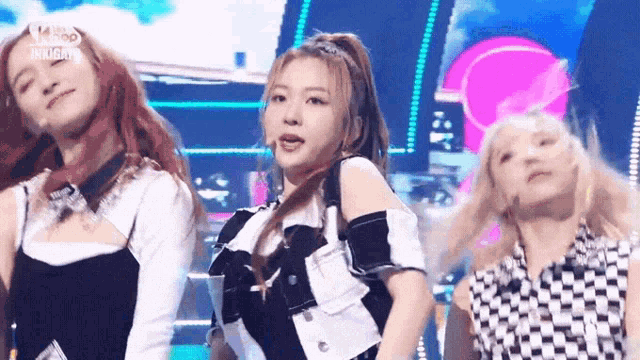 a group of young women are standing on a stage and dancing .