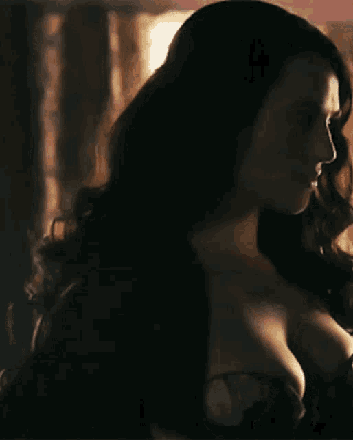 a close up of a woman 's shoulder and breast in a black dress