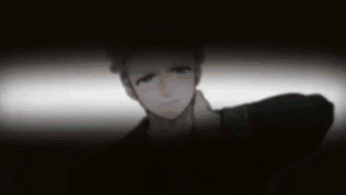 a blurry picture of a man in a dark room with a white background .