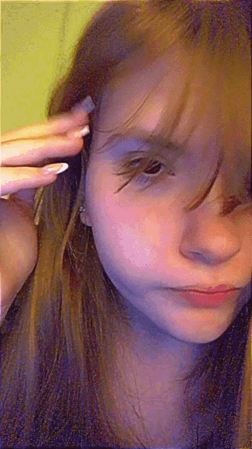a close up of a girl 's face with a purple and green background