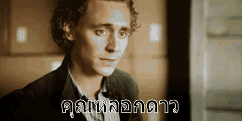 a man with curly hair is looking at the camera with a foreign language written on his face .