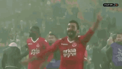 a soccer player wearing a red shirt that says arkia on it