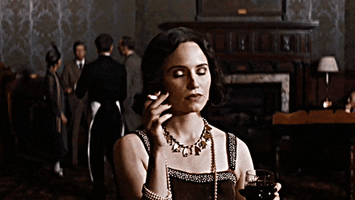 a woman smoking a cigarette while holding a wine glass
