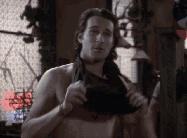 a man without a shirt is taking off his shirt