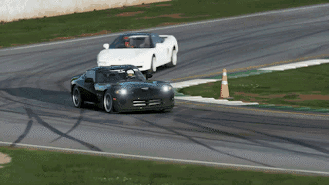 a black sports car is driving down a race track with other cars