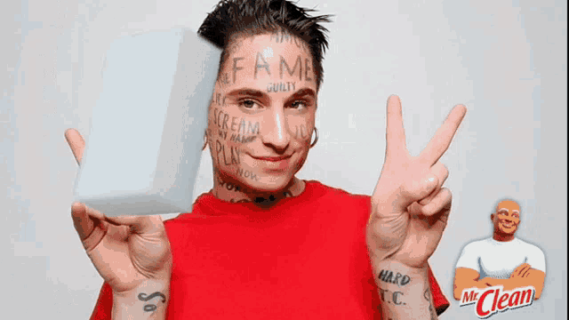 a man with a tattoo on his wrist is holding a white sponge in front of his face