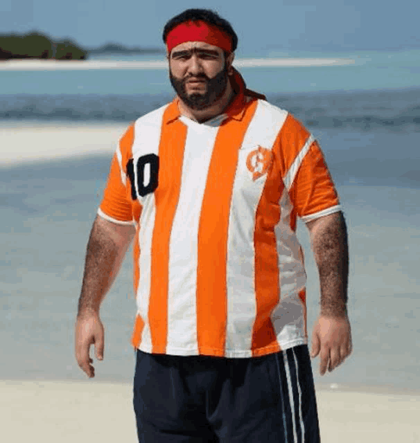 a man with a beard and a headband is wearing an orange and white striped shirt with the number 10 on it .