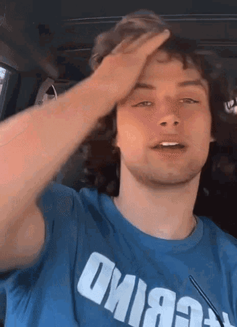 a young man wearing a blue t-shirt that says oviea