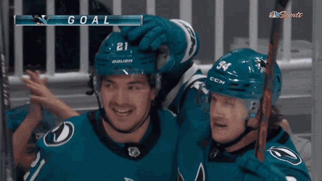 a hockey player with the number 21 on his helmet stands next to another player with the number 34 on their helmet