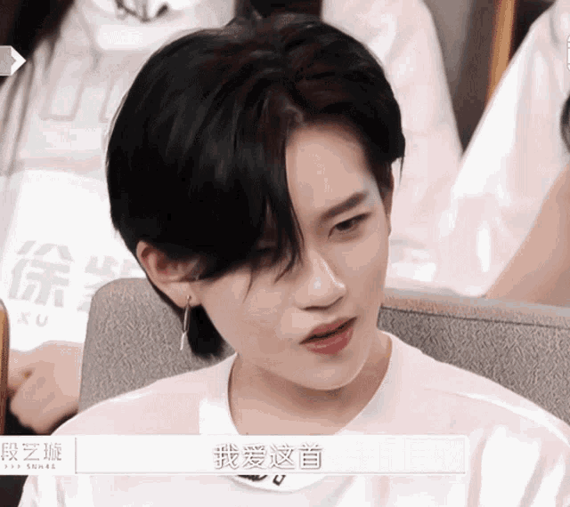 a woman with short black hair wearing a white shirt