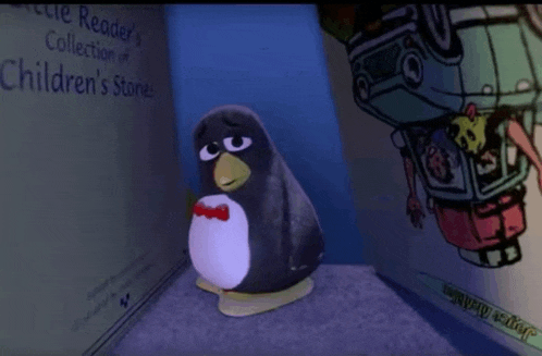 a stuffed penguin is sitting in front of a children 's book called little reader 's collection of children 's stories
