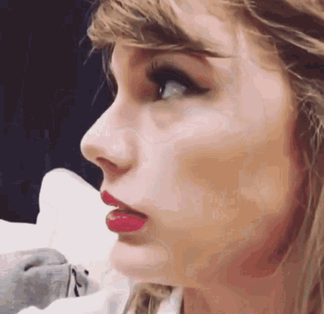 a close up of a woman 's face with red lipstick .