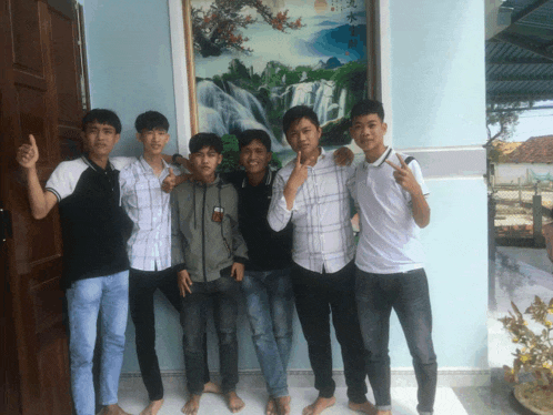 a group of young men are posing for a picture in front of a painting of a waterfall