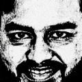 a close up of a man 's face with a beard and mustache smiling .