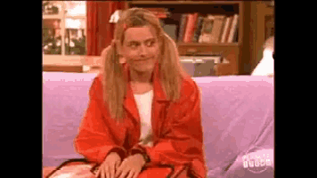a woman in a red jacket is sitting on a couch