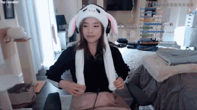 a woman wearing a bunny hat is sitting in front of a screen that says top donator on it