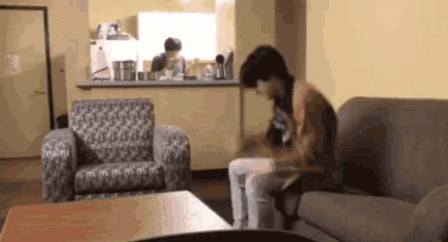 two people are sitting on a couch in a room
