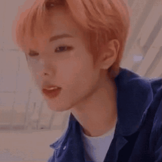 a close up of a person 's face with orange hair and a blue jacket .