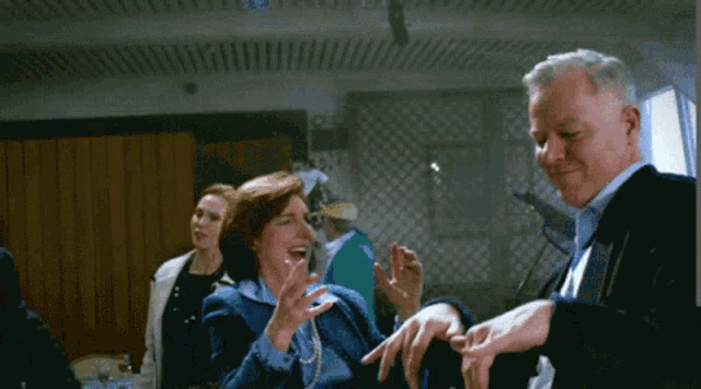 a man and a woman are dancing in a room and the woman is wearing a wedding ring