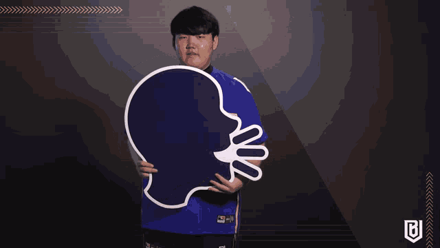 a man in a blue shirt is holding a silhouette of a person 's face