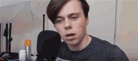 a young man is talking into a microphone in a room .